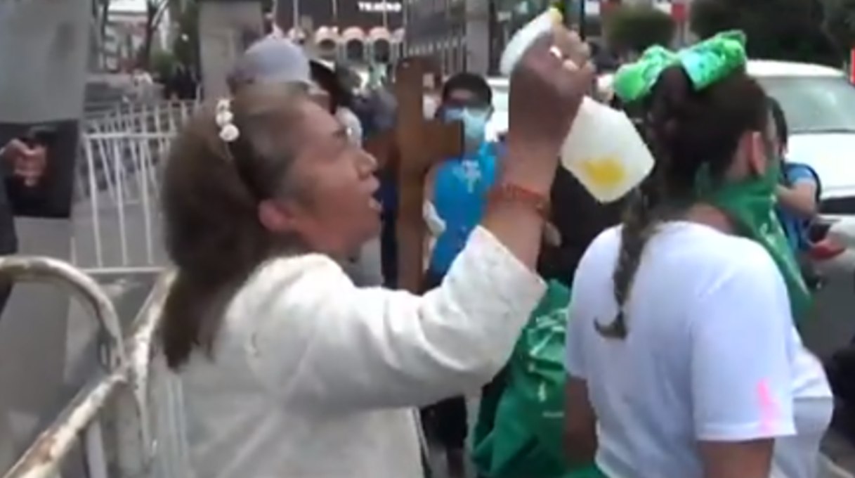 “Arroja a Satanás al infierno”: Con cruz en mano, mujer “exorciza” feministas durante marcha (VIDEO)